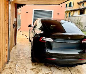 a black car parked outside of a garage at Villetta independente la Perla in Ceggia