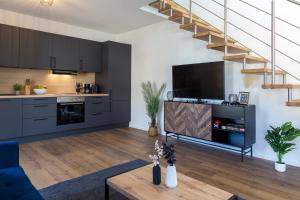 an open kitchen and living room with black cabinets at living TIMELESS- Europa Park Rheinhausen in Rheinhausen