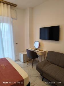 - une chambre avec un canapé et un bureau avec une télévision dans l'établissement Giurò, à Naples 16 autres photos