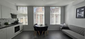 a kitchen and living room with a table and a couch at EMM Guesthouse in Ieper