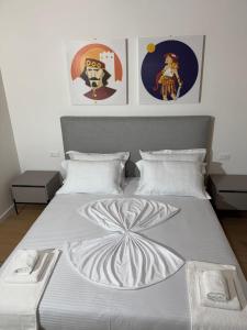 a bedroom with a large white bed with three pictures at Villetta independente la Perla in Ceggia