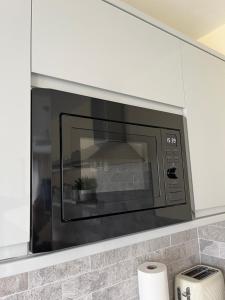 a microwave oven in a kitchen above a counter at Luxury Apartment Heald Green in Handforth