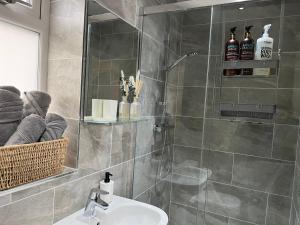 a bathroom with a shower with a sink and a mirror at Luxury Apartment Heald Green in Handforth +20 photos