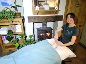 a woman sitting in a chair in front of a fireplace at Aldwark Bridge Glamping - Lunar Tent in Aldwark +34 photos