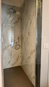 La salle de bains est pourvue d'une douche en marbre et d'une porte en verre. dans l'établissement Giurò, à Naples