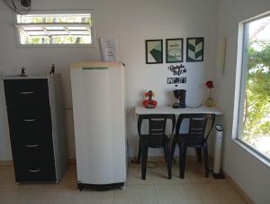 カボ・フリオにあるSuite Renascer Cabo Frioのテーブルと白い冷蔵庫のあるキッチン