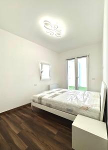 una camera da letto bianca con un letto e una finestra di NanuDomus a Villasimius Altre 7 foto