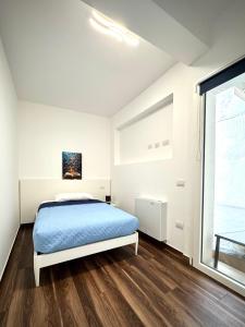 una camera da letto bianca con un letto e una finestra di NanuDomus a Villasimius
