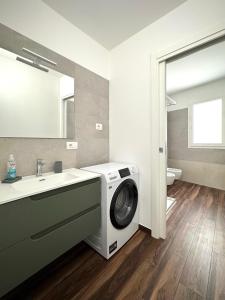 un bagno con lavatrice e lavandino di NanuDomus a Villasimius