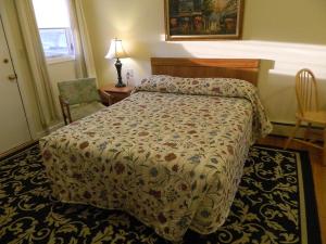 a bedroom with a bed and a table and a chair at Twin Oaks Motel in Manasquan