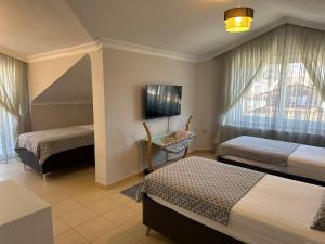 a hotel room with two beds and a tv at Villa Necati Bey in Marmaris +68 photos