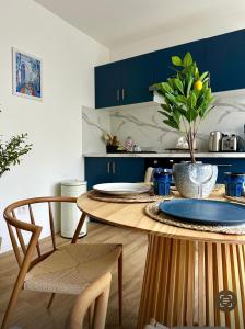 a kitchen with blue cabinets and a wooden table at La Grèce - Appartement chaleureux en hypercentre in Saint-Quentin