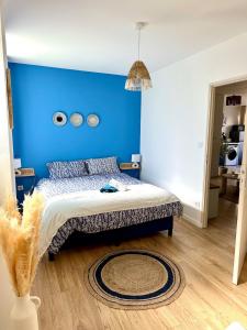 a blue bedroom with a bed with a blue wall at La Grèce - Appartement chaleureux en hypercentre in Saint-Quentin