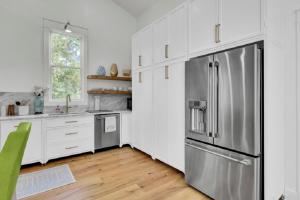 Una cocina con gabinetes blancos y un refrigerador de acero inoxidable. en Sandcrab Court 22 by Wild Dunes, Luxury Home, en Isle of Palms