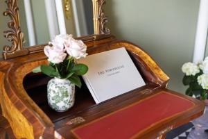 een vaas met roze bloemen op een tafel met een spiegel bij The Townhouse, Leith in Edinburgh