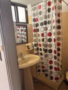 un bagno con lavandino e tenda da doccia di ALEKA Kos City Center Apartments a Città di Kos