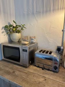 eine Mikrowelle und ein Toaster auf dem Tisch in der Unterkunft The Old Sty in Canterbury