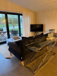 ein Wohnzimmer mit Sofa und Fernseher in der Unterkunft The Old Sty in Canterbury