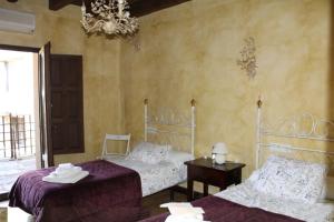 a bedroom with two beds and a chandelier at Cabachuelas I casas rurales in San Miguel de Valero