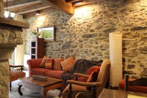 a living room with a couch and a stone wall at Cabachuelas I casas rurales in San Miguel de Valero +21 photos