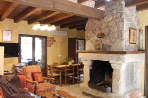 a living room with a stone fireplace and a dining room at Cabachuelas I casas rurales in San Miguel de Valero