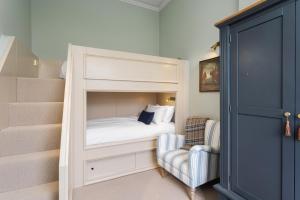 a small bedroom with a bunk bed and a chair at The Townhouse, Leith in Edinburgh
