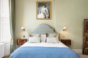 een slaapkamer met een bed met een blauwe en witte sprei bij The Townhouse, Leith in Edinburgh +16 foto's