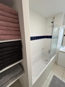 a bathroom with a walk in shower and towels at Magnifique 2 chambres - Parking - Netflix - Gare in Arras
