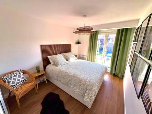 a bedroom with a bed and a chair and a window at Magnifique 2 chambres - Parking - Netflix - Gare in Arras