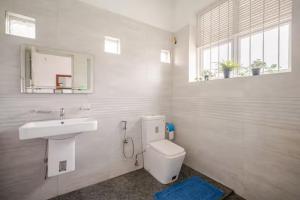 une salle de bain blanche avec un lavabo et des toilettes dans l'établissement Spacious Eco Guest House Colombo, à Sri Jayewardenepura Kotte 127 autres photos