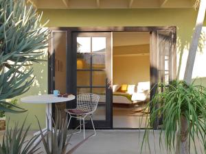 a patio with a table and a bed in a room at Hope Springs Resort in Desert Hot Springs