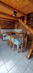 a dining room with wooden tables and chairs in a cabin at Murmullos del bosque in Lago Puelo