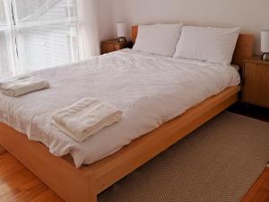 a large bed with white sheets and towels on it at Holiday Home in Lakes Entrance! in Lakes Entrance