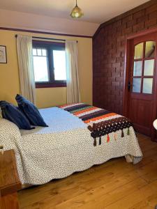 a bedroom with a bed with a blanket on it at La casa Florencia in Puerto Varas +13 photos