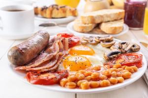 a plate of breakfast food with eggs sausage and beans at Caesars Place Guest House in Kathu