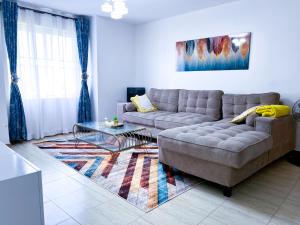 a living room with a couch and a glass table at Dream Villa in Ongata Rongai 