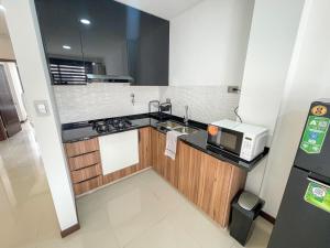 a small kitchen with a sink and a microwave at 2-bedroom apartment & Free parking in Santa Cruz de la Sierra