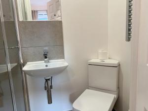 a white bathroom with a toilet and a sink at En-suite double room on riverside of Canada Water in London