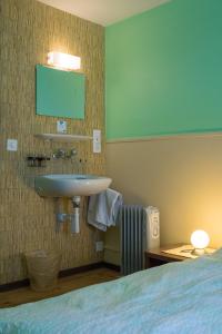 a bathroom with a sink and a bed at Budget Waldhotel Unspunnen in Interlaken
