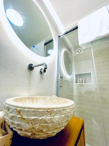 a bathroom with a stone sink and a mirror at B&B Rival room e suite in Andria