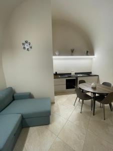 a living room with a blue couch and a table at B&B Rival room e suite in Andria