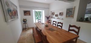 a dining room with a wooden table and chairs at Maison familiale Baylère - Piscine et spa - 8 pers in Buzy
