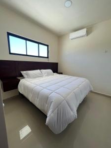ein Schlafzimmer mit einem großen weißen Bett mit einem Fenster in der Unterkunft Pelicanos Residencial in Puerto Peñasco