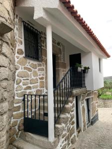 a stone house with a balcony and a staircase at Casa da Fonte in Mangualde