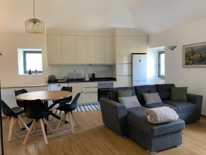 a living room with a couch and a table and a kitchen at Casa da Fonte in Mangualde