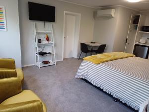 una camera da letto con un letto, una sedia e un tavolo di Rotorua Studio a Rotorua