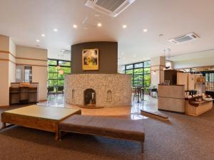 a living room with a fireplace with a couch in front of it at Hayataro Onsen Komagane Kogen Retreat Suzuran Haya - Vacation STAY 34206v in Komagane