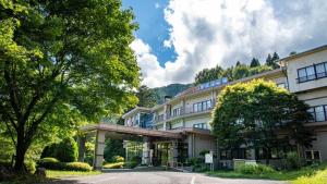Un gran edificio con un árbol delante. en Hayataro Onsen Komagane Kogen Retreat Suzuran Haya - Vacation STAY 34151v, en Komagane