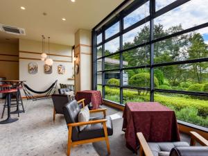 a living room with large windows and a table and chairs at Hayataro Onsen Komagane Kogen Retreat Suzuran Haya - Vacation STAY 34214v in Komagane