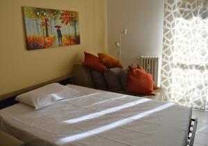 a bedroom with a bed and a couch and a painting at Casa Alice in Milano Parco Nord in Bresso
